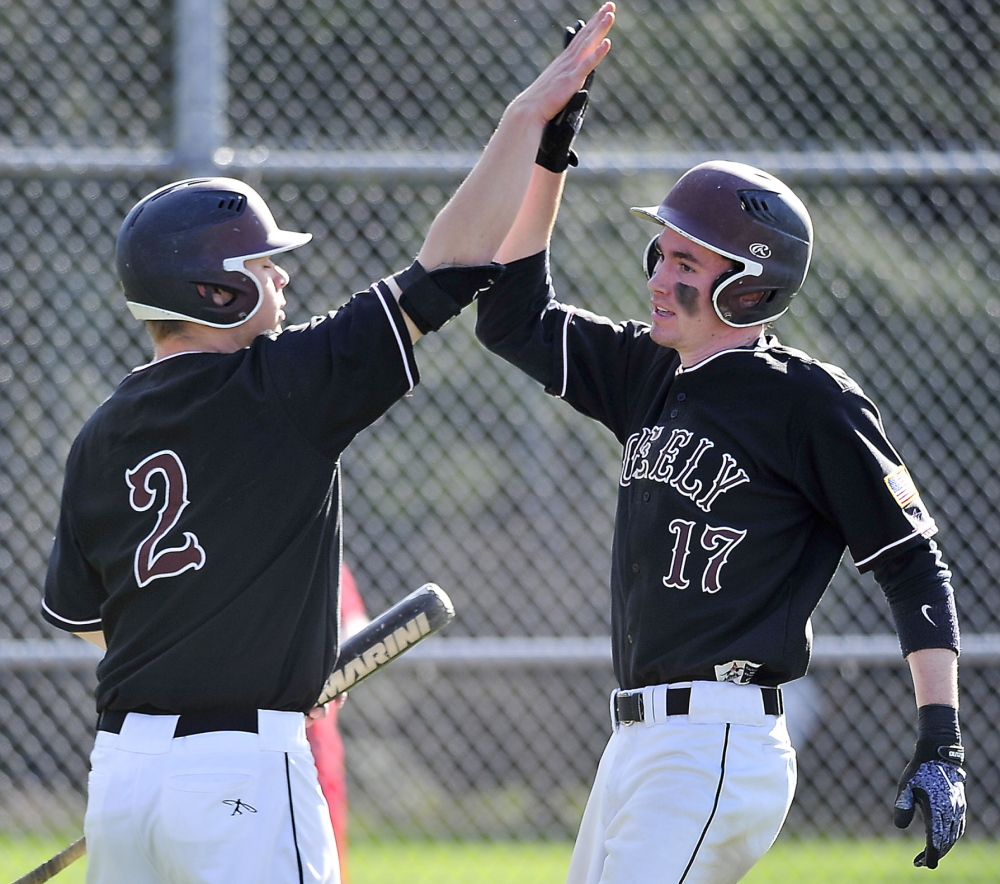 Will Bryant of Greely, left, welcomes Sam Porter, who scored an early run Wednesday against Yarmouth. Greely improved its record to 5-1 by scoring in the bottom of the seventh inning for a 5-4 victory.