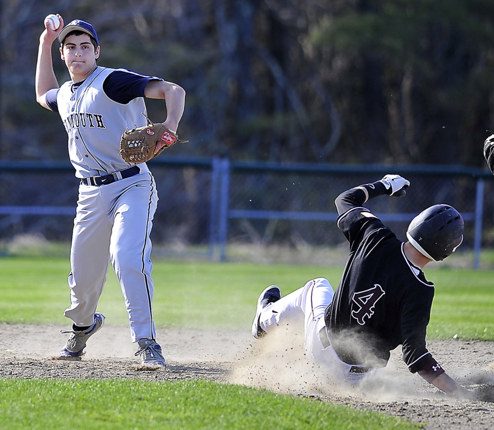 Shortstop Cody Cook of Yarmouth throws to first base to end an inning as Miles Shields of Greely slides into second base during their Western Maine Conference game at Cumberland.