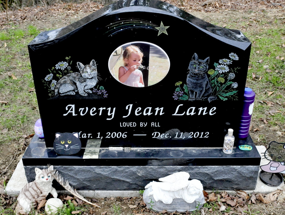 Avery Lane’s grave at the Friends Cemetery has a polished black granite marker that’s etched with a photo of her blowing bubbles, along with engraved images of two cats.