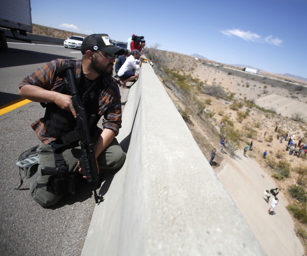 Locked and loaded, Eric Parker of Idaho keeps watch from a bridge along with other supporters of controversial Nevada cattleman Cliven Bundy last month.