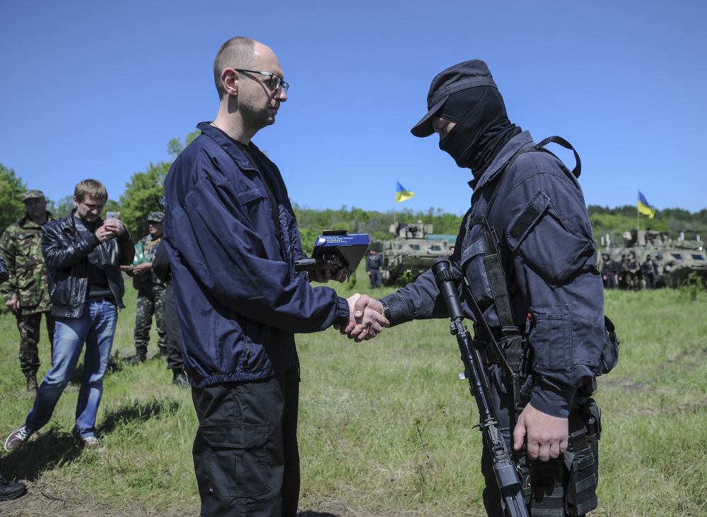 Ukrainian Prime Minister Arseniy Yatsenyuk, left, shakes hands with a Ukrainian soldier at a checkpoint in Slovyansk, Ukraine, Wednesday. Ukrainian military operations that began Monday to expunge pro-Russia forces from the city of Slovyansk have been the interim government’s most ambitious effort so far to quell weeks of unrest in Ukraine’s mainly Russian-speaking east.