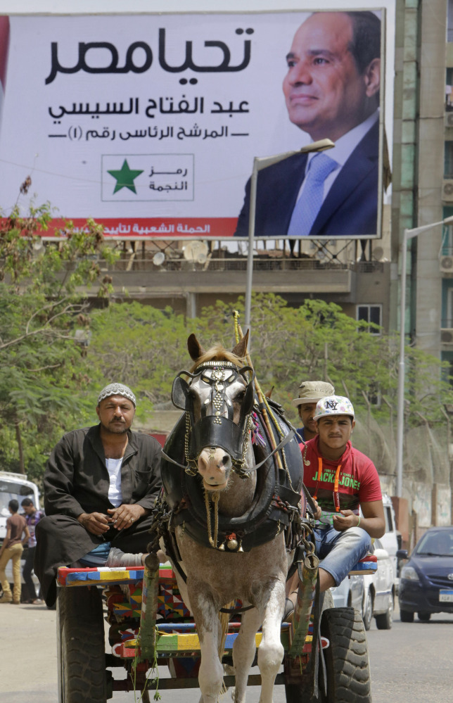 Egyptian villagers make their way on a horse cart past a campaign billboard of presidential hopeful Abdel-Fattah el-Sissi in Cairo, Egypt, on Thursday.