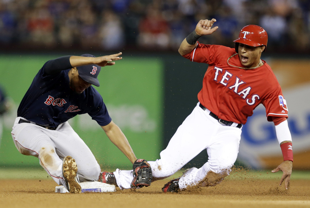 Red Sox shortstop Xander Bogaerts, left, is knocked backward after tagging out Leonys Martin of the Rangers as Martin was trying to steal second in the fourth inning.