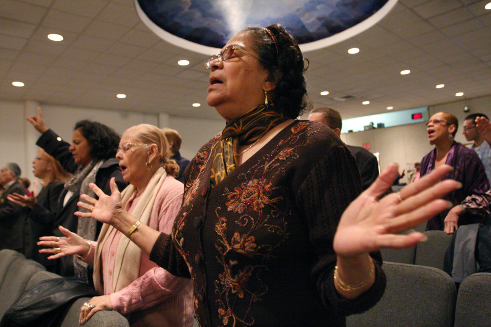 Maria Antonetty, foreground, attends a service at the Primitive Christian Church in New York in April 2009. Latinos in the United States are abandoning Roman Catholicism in increasing numbers to become evangelical Protestants or to leave organized religion.