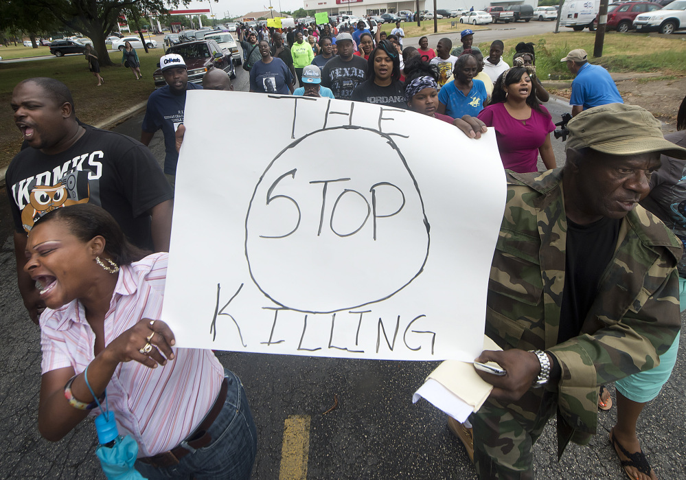 Protesters carry signs outside the Hearne, Texas, police department Thursday following the shooting death of 93-year-old Pearlie Golden by Officer Stephen Stem.
