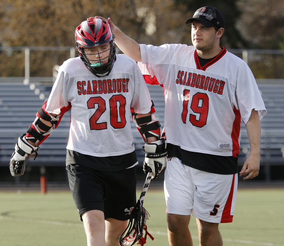 Scarborough junior varsity lacrosse player Teddy Prosack, right, gives a pat on the head to teammate Austin Pietras after his shift May 1 during a game at Fitzpatrick Stadium. Both players will be at Autism Awareness games Saturday.