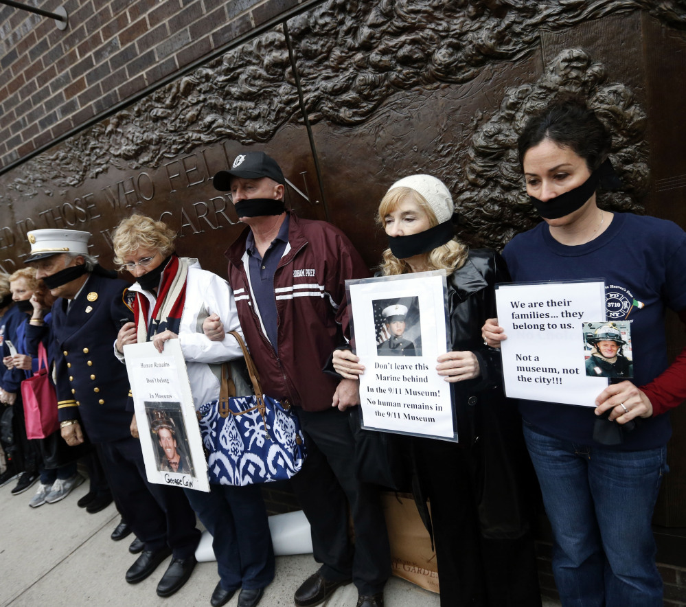 Family members of victims of the Sept. 11, 2001, attacks wear black gags over their mouths in protest of the transfer of unidentified remains to the World Trade Center site.