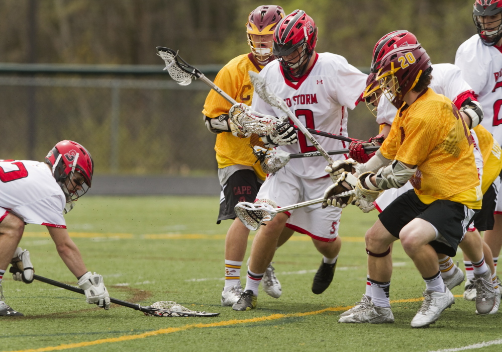 Scarborough goalie Jordan Flannery, left, covers the ball as a crowd of Cape Elizabeth and Scarborough players move in during a boys’ lacrosse game at Scarborough on Saturday. Unbeaten Cape Elizabeth handed the Red Storm their first loss of the season, 10-5.