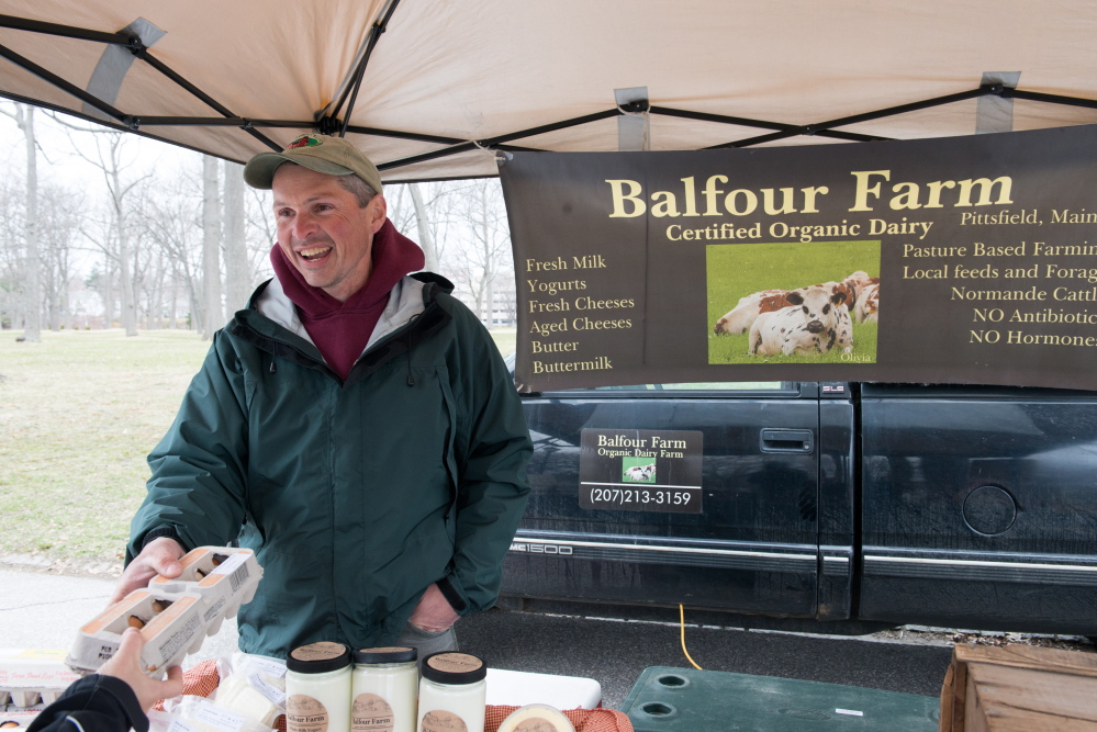 Doug Donahue of Balfour Farm hands a dozen organic eggs to Susan Axelrod at the Portland Farmers’ Market. Friendly farmers and a convivial atmosphere are among the perks of shopping at farmers markets.