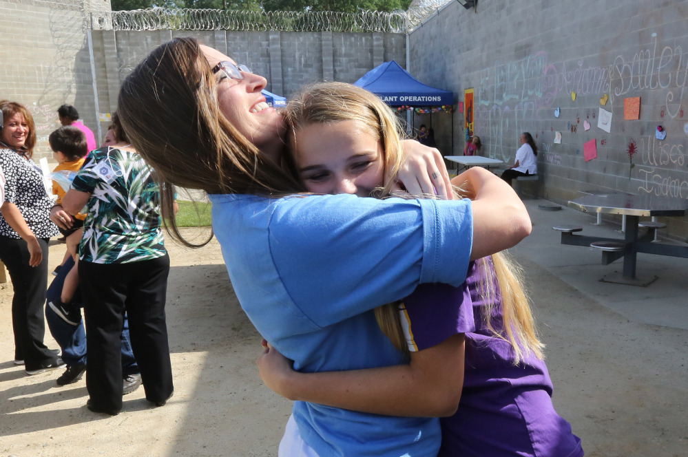 Tiffany Dugan, left center, hugs her daughter, Arianne Skelton, 13, during an early Mother’s Day visit on May 3 at the Folsom Women’s Facility in Folsom, Calif.