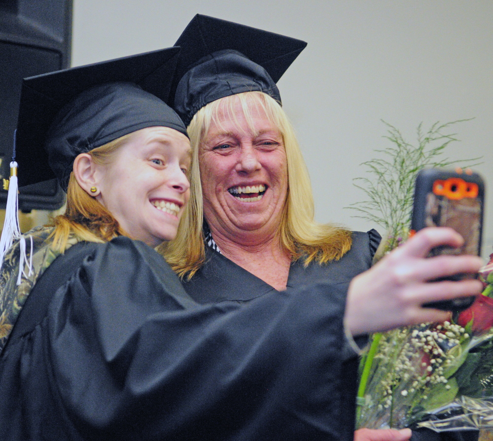 Nicole “Sis” Trask, left, takes a picture with her mother, Kathy Trask, on Saturday before they walked in the University of Maine at Augusta graduation ceremony.
