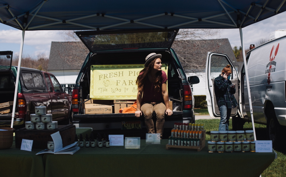 Crystal Ouimette of Fresh Pickins Farm in Limington and Windham takes in the afternoon sun during the opening weekend of the Crystal Springs Farmers Market in Brunswick this month.