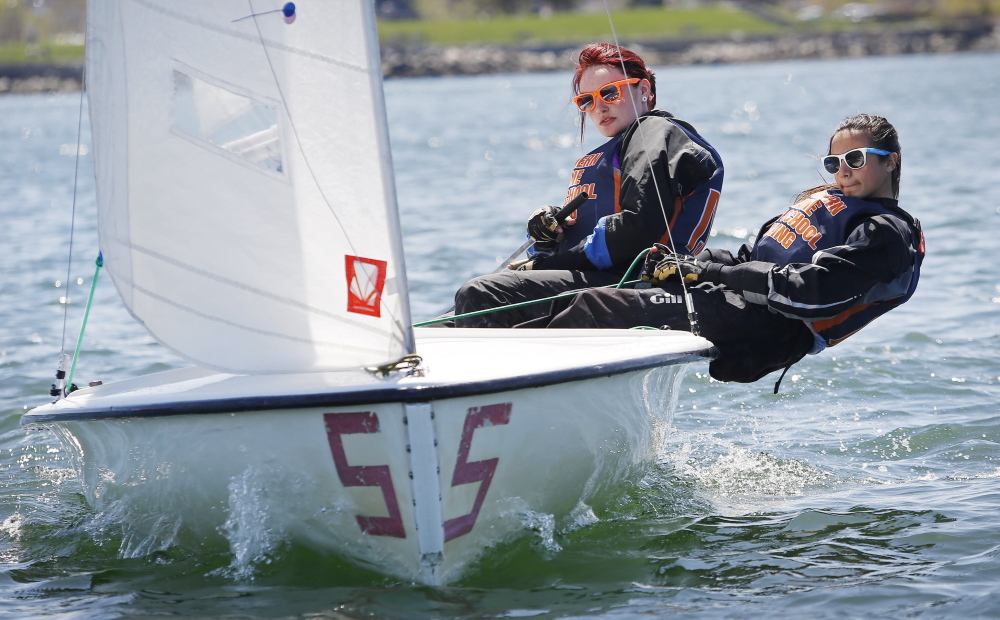 Waynflete School freshman Kelley Frumer, right, “hikes out” to take full advantage of the wind as she and teammate Elizabeth Newberry, a senior at Bonny Eagle High School, compete in Sunday’s regatta.