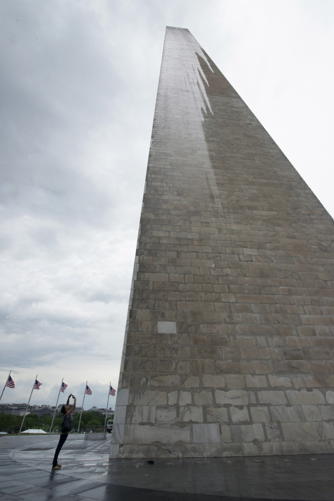 In this Saturday, May 10, 2014 photo, a journalist photographs the Washington Monument during a press preview prior to the re-opening of the monument, in Washington.