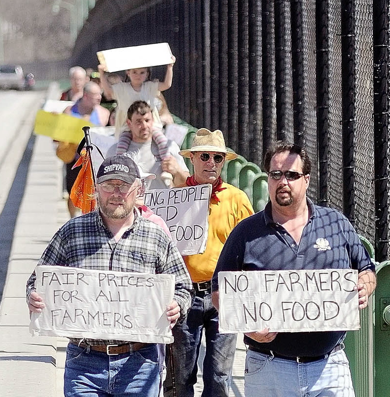 Dan Brown, right, owner of Gravelwood Farm in Blue Hill, leads supporters over a bridge during a 2012 march in Augusta.