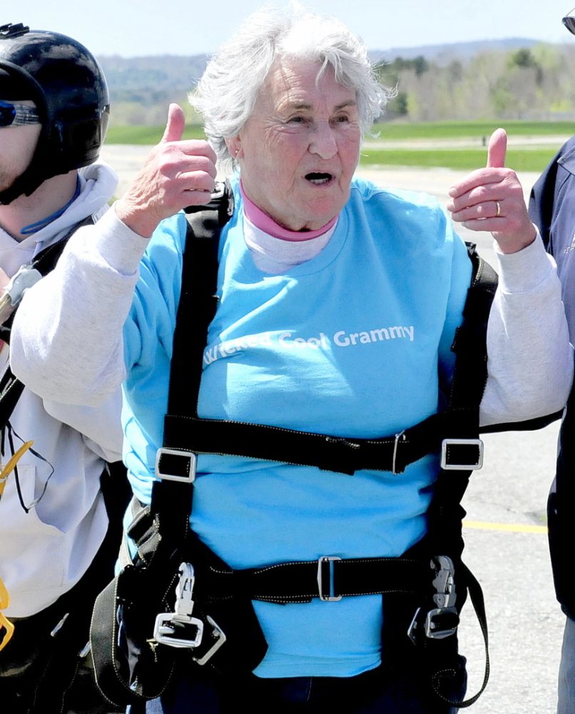 Marjorie Bell, who turned 80 on Saturday, gives the thumbs-up sign to family members after she successfully skydived in tandem at LaFleur Airport in Waterville.
