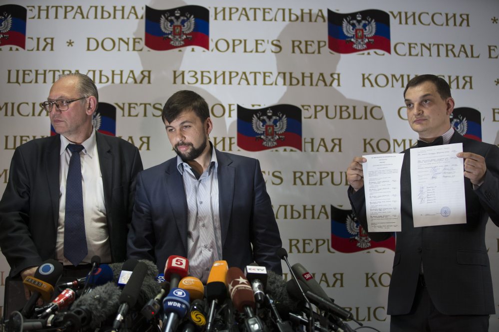 Boris Litvinov, left, co-chairman of the Presidium of the People’s Republic of Donetsk; Denis Pushilin, insurgent leader and head of the elections commission of the so-called Donetsk People’s Republic; and vote-counter Roman Lyagin show documents with the results of Sunday’s referendum to journalists at a news conference in Donetsk, Ukraine, Monday.