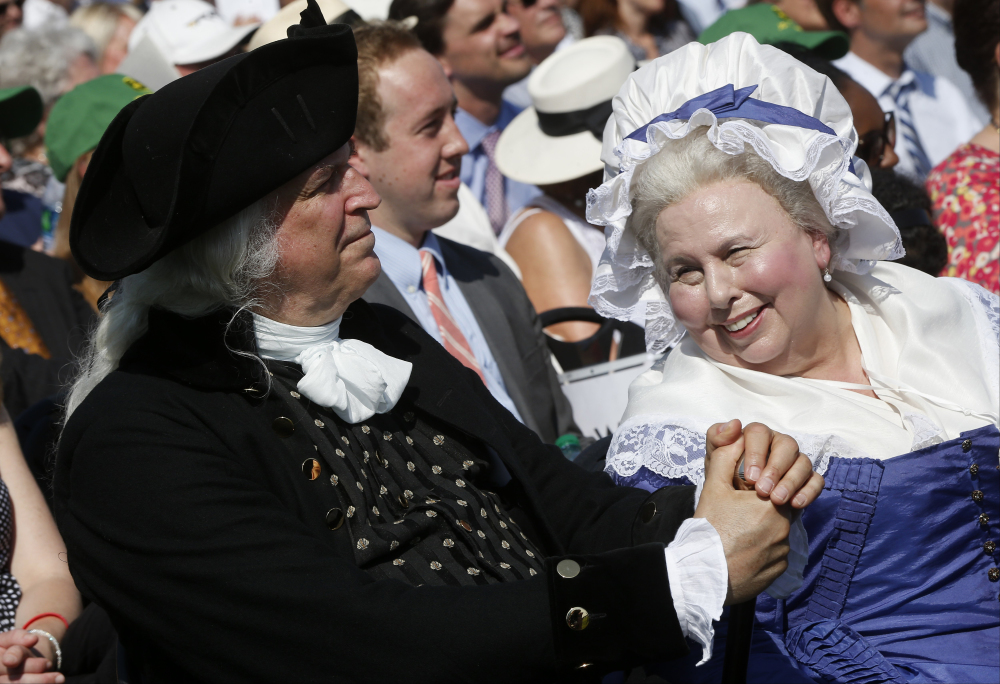 George Washington, played by Dean Malissa, left, and Martha Washington, played by Mary Wiseman, attend a ceremony to celebrate the reopening of the Washington Monument on Monday. The monument sustained damage from an earthquake in August 2011.