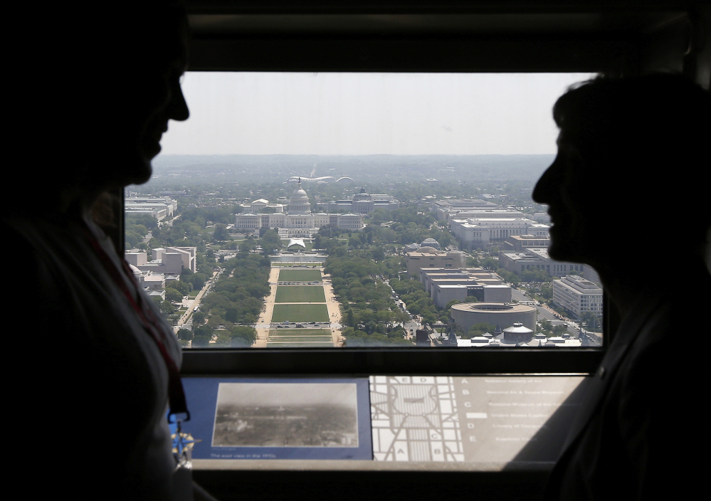 Kristin Beck, a former Navy SEAL, left, talks with Interior Secretary Sally Jewell inside the Washington Monument looking toward the Capitol on Monday.