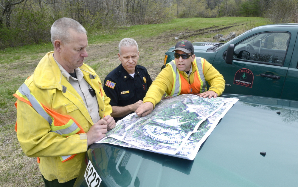 Maine Forest Rangers Mark Rousseau, left, and John Leavitt, right, are joined by Saco Fire Department Deputy Chief Robert Martin as they assess fire damage last week.
