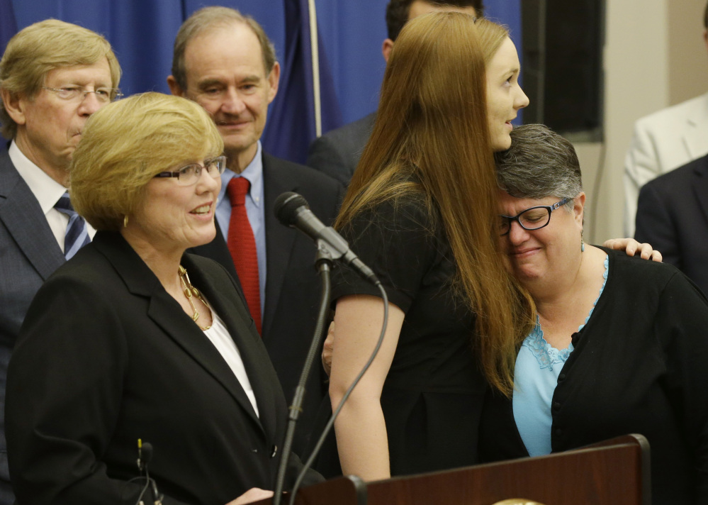 Plantiffs in the federal suit over Virginia's ban on gay marriage, Mary Townley, left, Emily Schall-Townley, center, and Carol Schall react to comments during a news conference after a hearing on Virginia's same sex-marriage ban in Richmond on Tuesday.