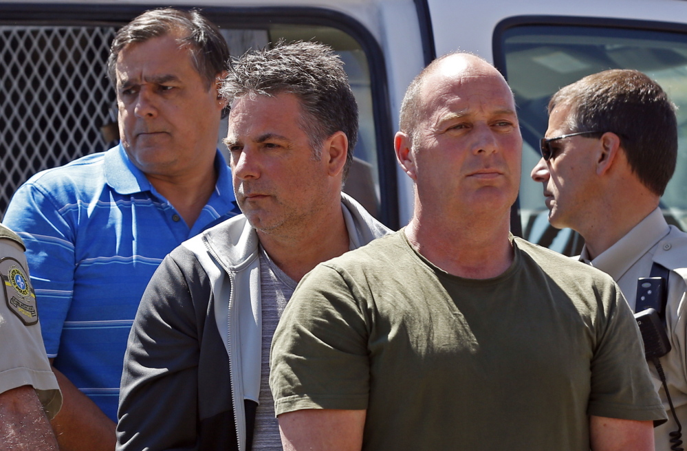Thomas Harding, right, Jean Demaitre, center, and Richard Labrie are escorted by police officers as they arrive at the courthouse in Lac-Megantic, Quebec, on Tuesday.