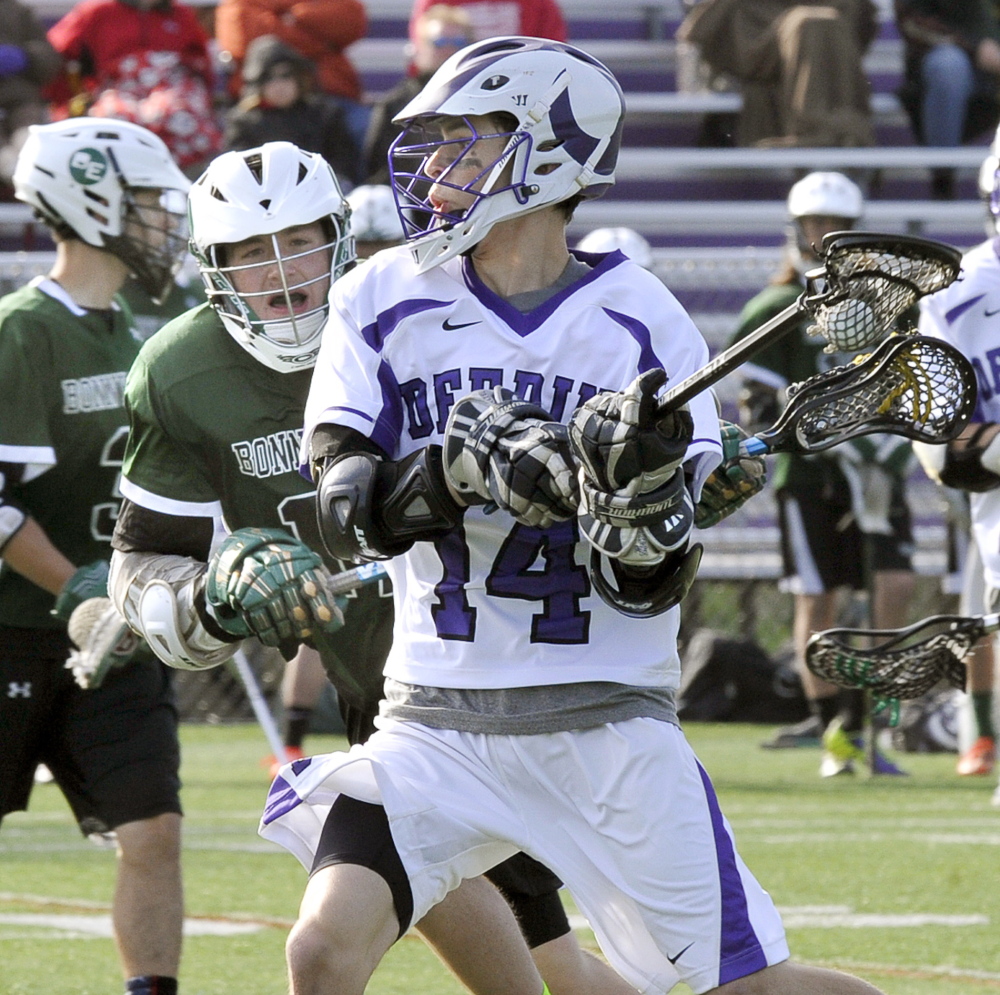 Nate Richards of Deering looks for a shot as Jason Harmon of Bonny Eagle closes in. Deering improved to 2-4 and dropped the Scots to 3-4.