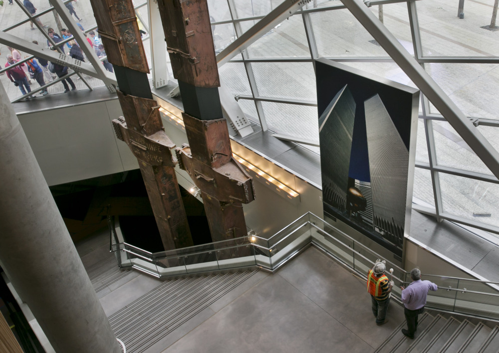 Visitors to the Sept. 11 Memorial, left, peer at pair of World Trade Center tridents, that once formed part of the exterior structural support of the east facade of the building, in the Sept. 11 Museum, in New York.