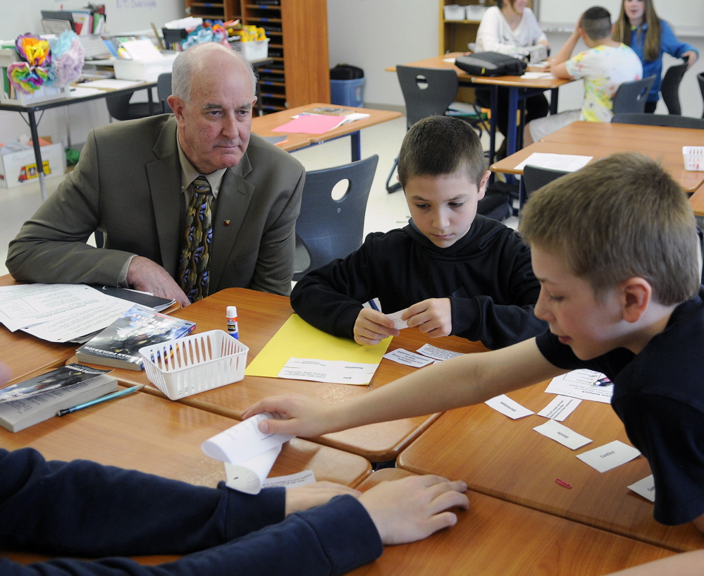 Education Commissioner Jim Rier watches Cony Junior High students work on a language arts problem. The Junior High raised its state report card grade from a D to a C this year.