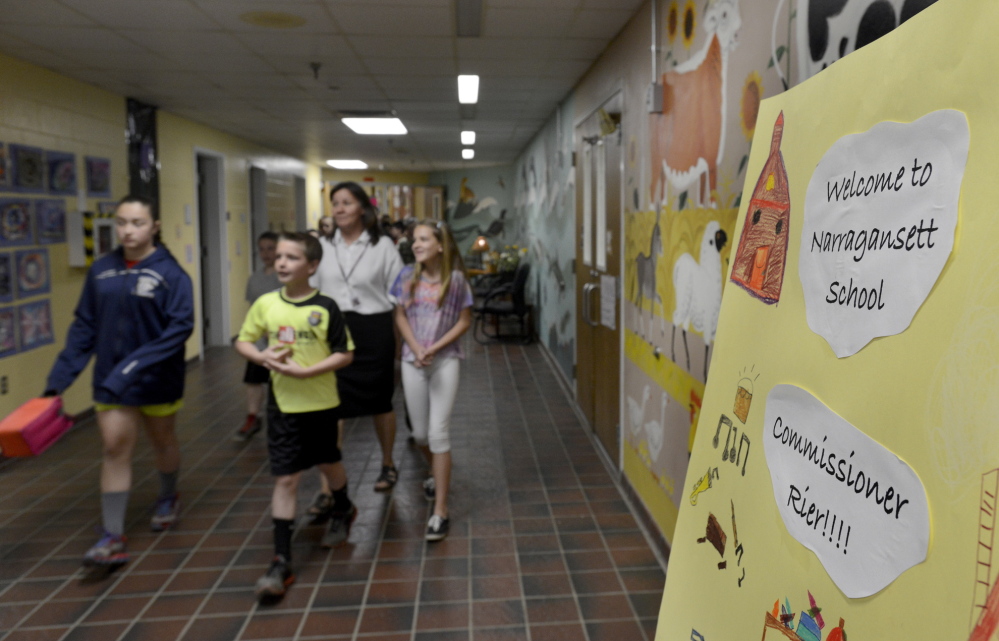 Fifth-graders Danielle Eid, Nathan Eichner and Alison Walker change classes Thursday at the Narragansett School in Gorham. The school’s grade jumped from a C to an A, earning a visit from Education Commissioner Jim Rier.
