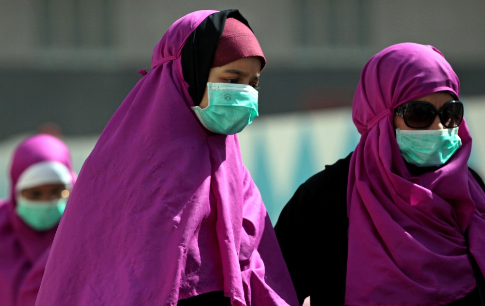 Muslim pilgrims in Mecca, Saudi Arabia, wear surgical masks to prevent infection from the respiratory virus known as the Middle East respiratory syndrome.