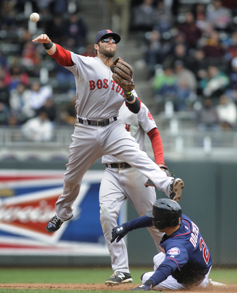 Boston Red Sox second baseman Dustin Pedroia sails over the Minnesota Twins second baseman Brian Dozier after getting the force at second in the fourth inning Thursday.