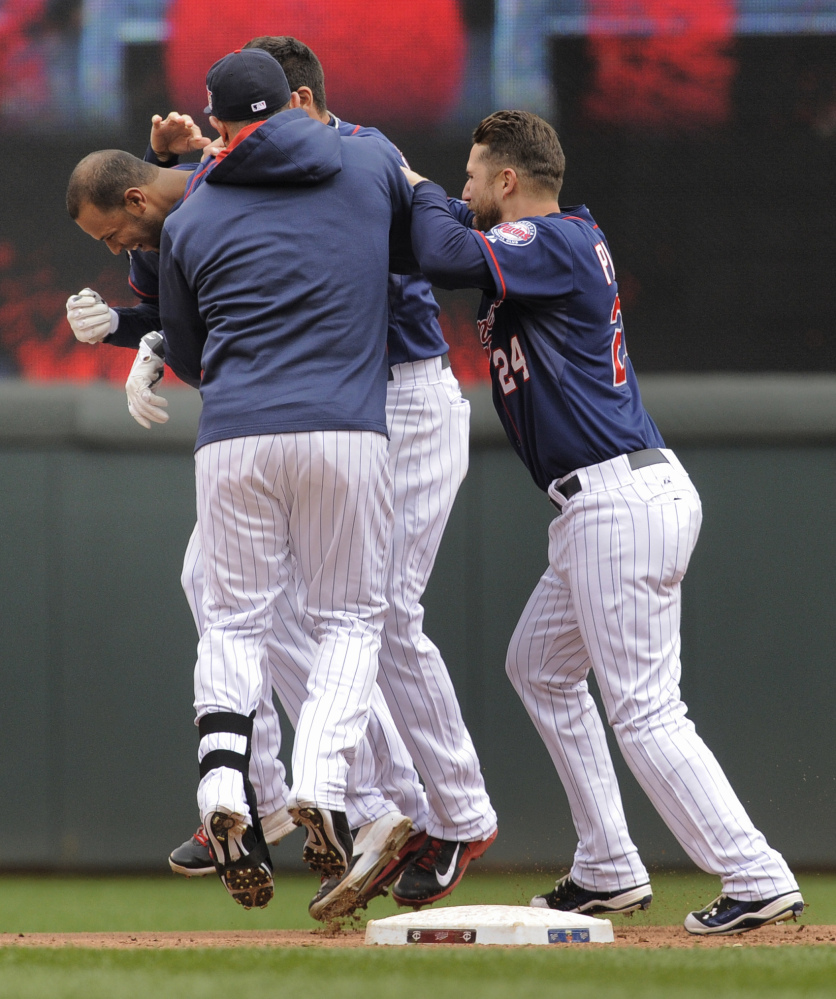 Teammates mob Minnesota Twins center fielder Aaron Hicks after he singled to bring in the winning run against the Boston Red Sox in the 10th inning in Minneapolis on Thursday.