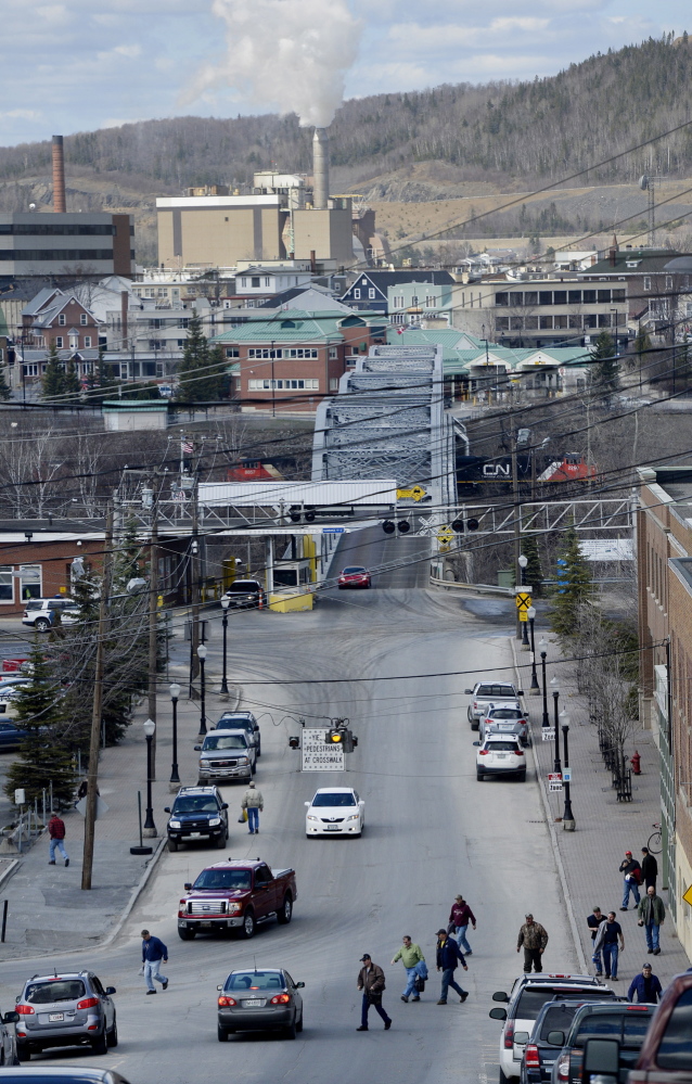 Workers file onto Bridge Avenue after a shift at the Twin Rivers Paper Co. mill in Madawaska. Edmundston, Canada. the neighboring community, can be seen across the bridge. Although Madawaska’s median income is only about $33,500 a year, most older men have made a decent living working union jobs at the mill.