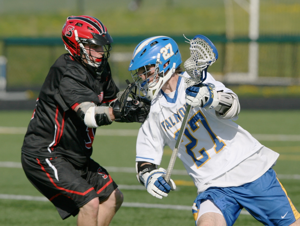 Caleb Delisle, left, of Scarborough tries to stop Falmouth’s Bryce Kuhn as he heads toward the goal Saturday during a boys’ lacrosse game in Scarborough. Falmouth won, 15-11.