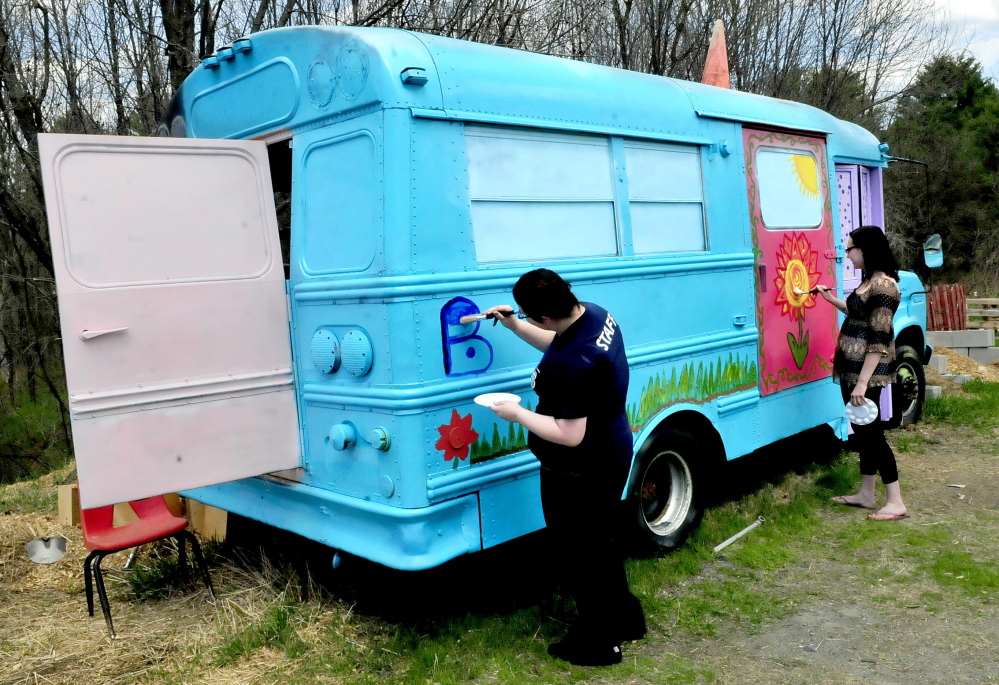 Sustainable agriculture program students Jade Oliver, left, and Savannah Witham decorate the “Bunny Bus” at the Marti Stevens Learning Center in Skowhegan.