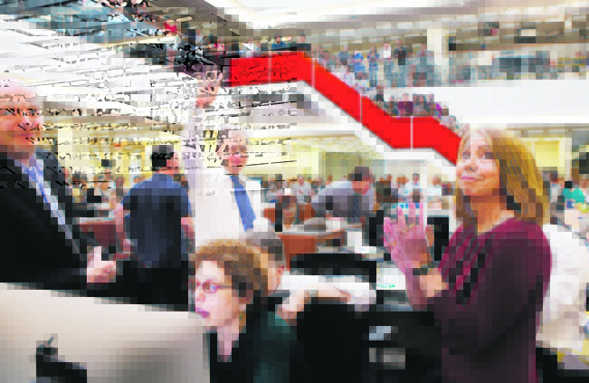 Publisher Arthur Sulzberger Jr. holds up four fingers to indicate the four Pulitzer Prizes won by the New York Times in April 2013. Jill Abramson is at right.