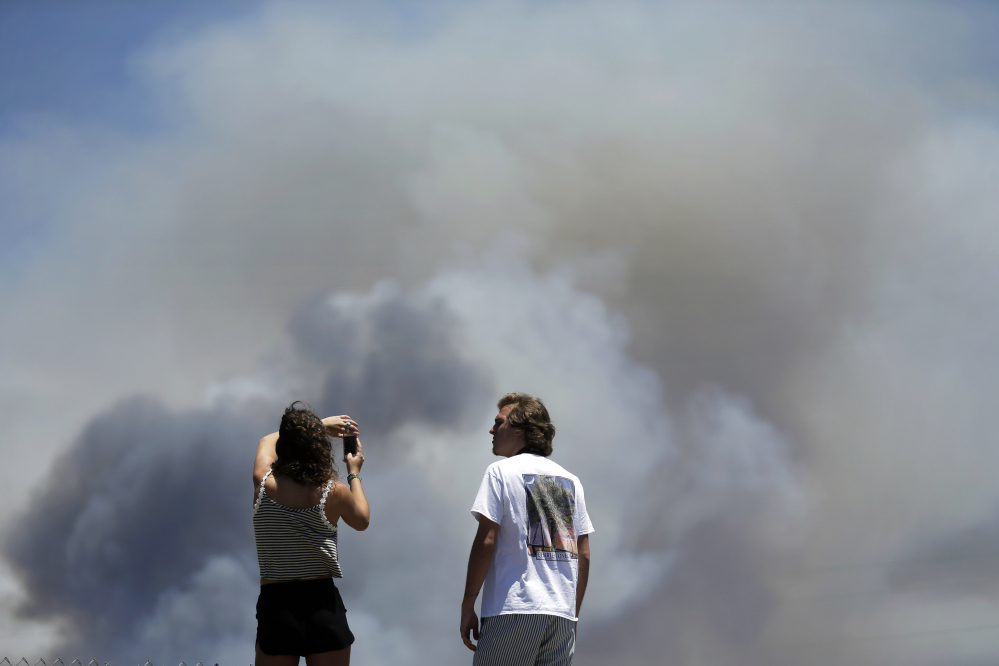 Chase and Brittany Boslet take pictures Friday of smoke from the Las Pulgas fire burning at Camp Pendleton near Oceanside, Calif.
