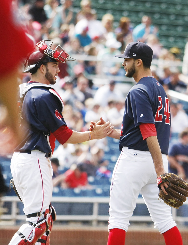 Sea Dogs catcher Blake Swihart gives a hand to relief pitcher Noe Ramirez, who had a 1-2-3 ninth inning after starter Mike Aguliera went eight strong innings in a win at Hadlock Field on Sunday.
