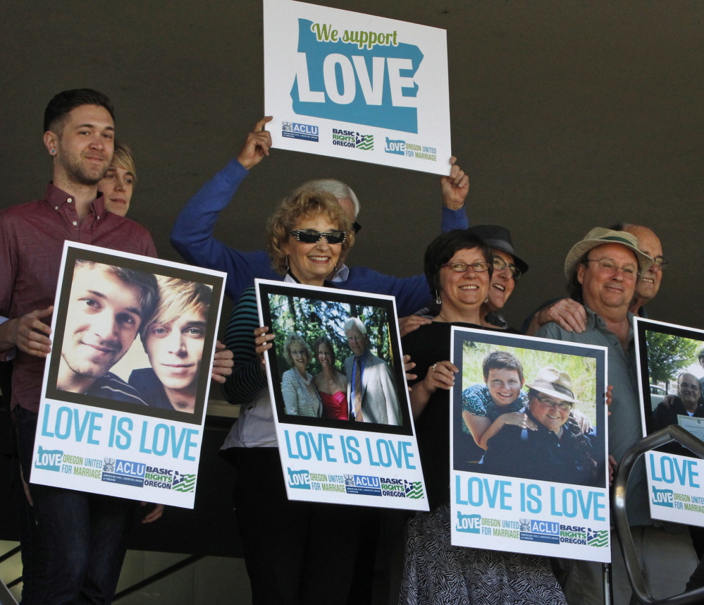 Supporters of same-sex marriage hold photos of themselves and their family members or partners on the steps of the Wayne L Morse U.S. Courthouse on May 14 in Eugene, Ore.