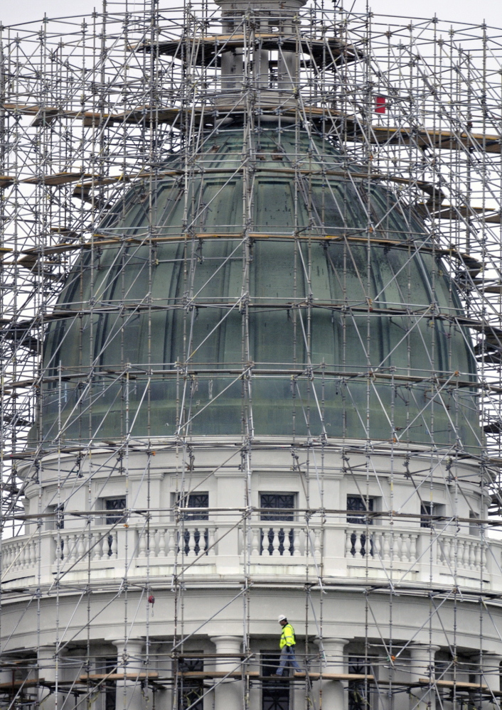 A worker walks on the staging at the State House dome in Augusta on Monday. Lawmakers are discussing how to use the dome’s copper.
