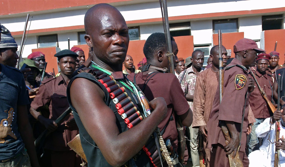 Armed traditional hunters gather in Maiduguri, Nigeria, on Sunday. Hundreds of hunters armed with homemade rifles, poisoned arrows and amulets say their spiritual powers and local knowledge can lead them to the nearly 300 schoolgirls abducted by Islamic extremists.