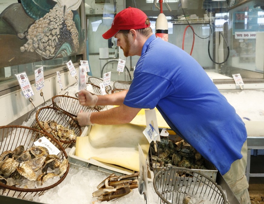 Retail manager Dan Kraus stocks shellfish Monday at Harbor Fish Market on the Portland waterfront. In a survey of nearly 600 Mainers, two-thirds of respondents said they had bought “fish, seafood or shellfish” in the past month, but only 47 percent of it came from Maine waters.