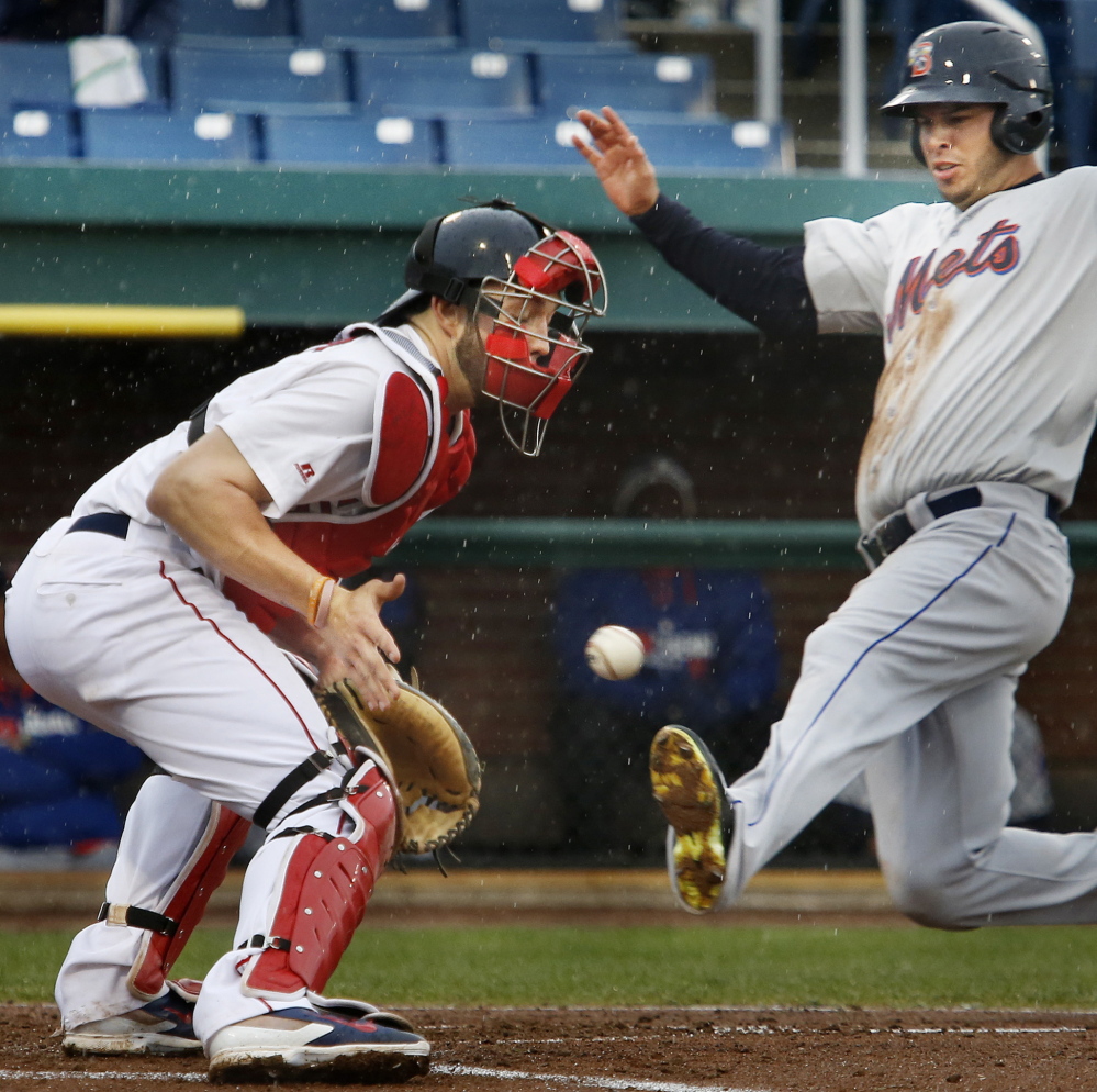 Matt Clark of the Binghamton Mets scores in the fourth inning of the first game Monday night as catcher Blake Swihart of the Portland Sea Dogs waits for the throw. Binghamton won the first game 5-0, but the Sea Dogs came back for an 8-2 victory in the second game at Hadlock Field.
