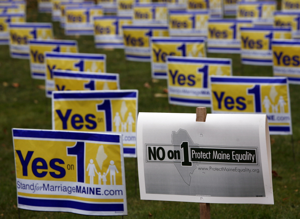 Posters urging Mainers to vote for a campaign to repeal Maine’s same-sex marriage law are seen in Portland in 2009, along with a “No on 1” campaign poster. Maine’s ethics panel should follow investigators’ recommendations and require the nonprofit that was the chief organizer of “Yes on 1” to register with the state and identify major funders.
