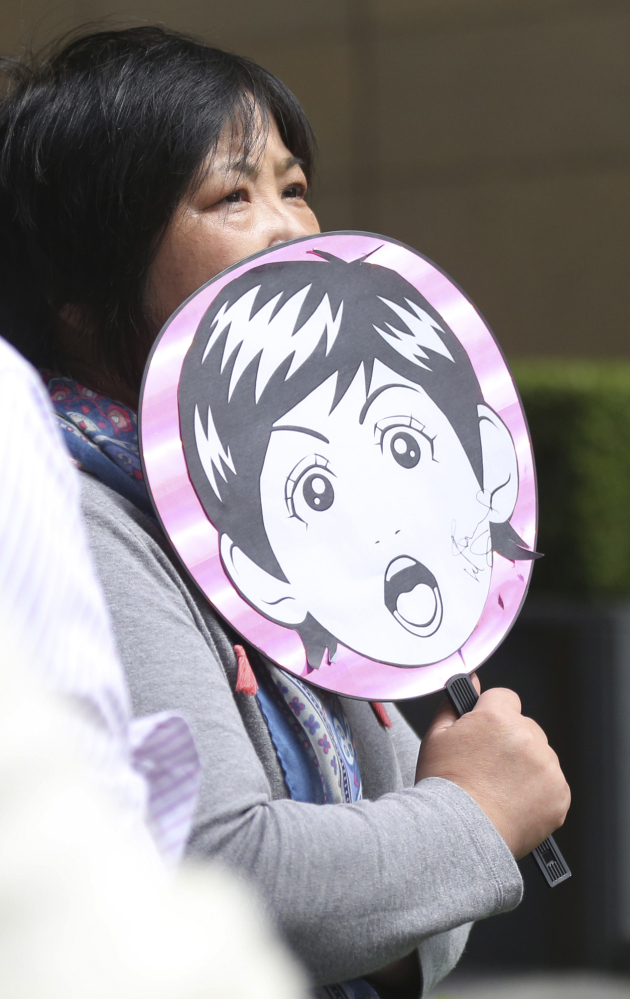 A fan of Paul McCartney waits outside a hotel where he is thought to be staying Tuesday in Tokyo.