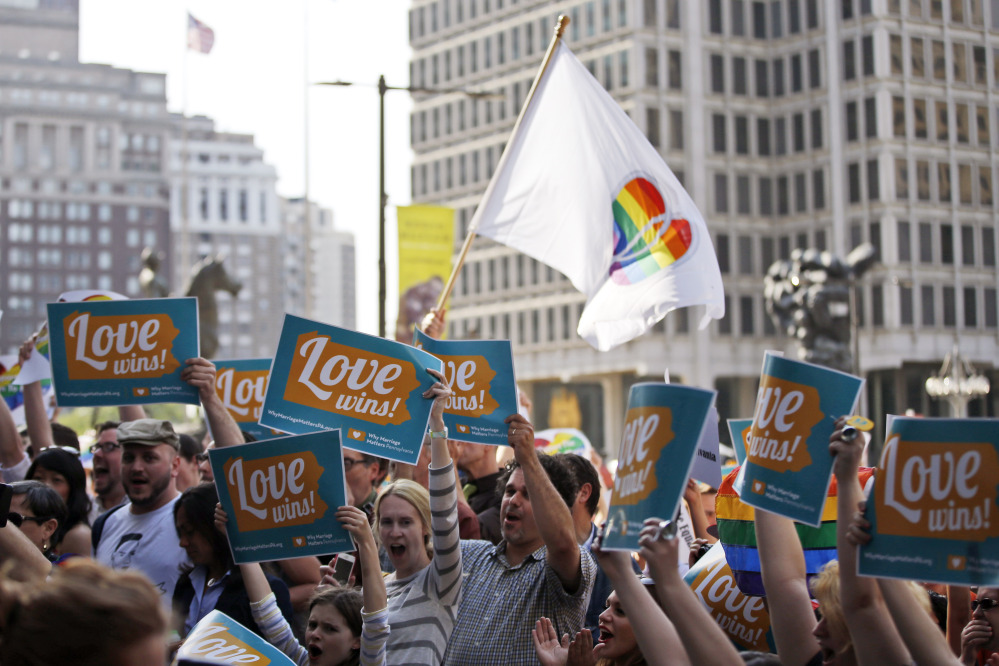People hold up signs and cheer during a rally at Philadelphia City Hall on Tuesday.