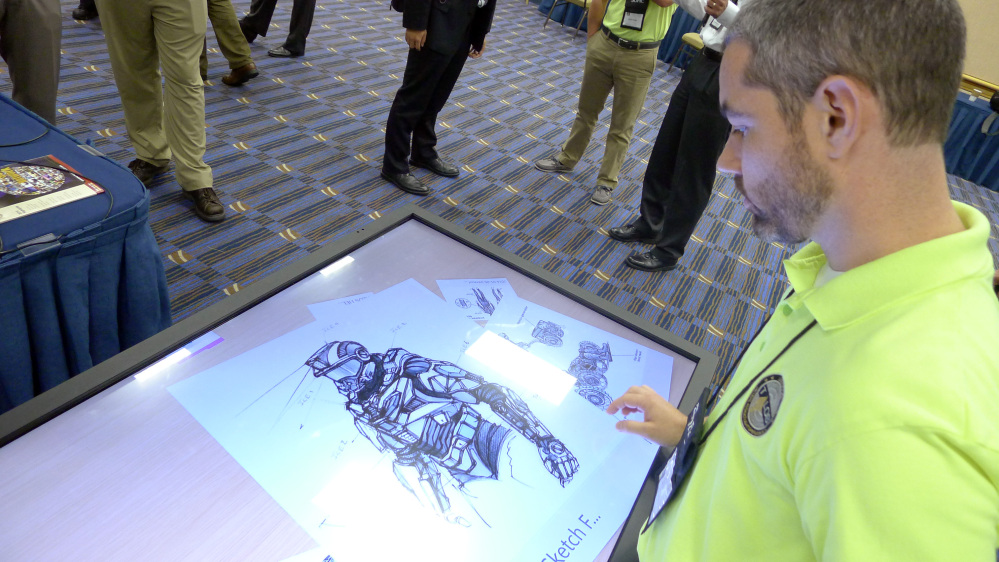 Michael Fieldson, the civilian project manager for the Tactical Assault Light Operator Suit at McDill Air Force Base, looks at sketches of the body armor exoskeleton during the Special Operations Forces Industry Conference in Tampa, Fla., on Monday.