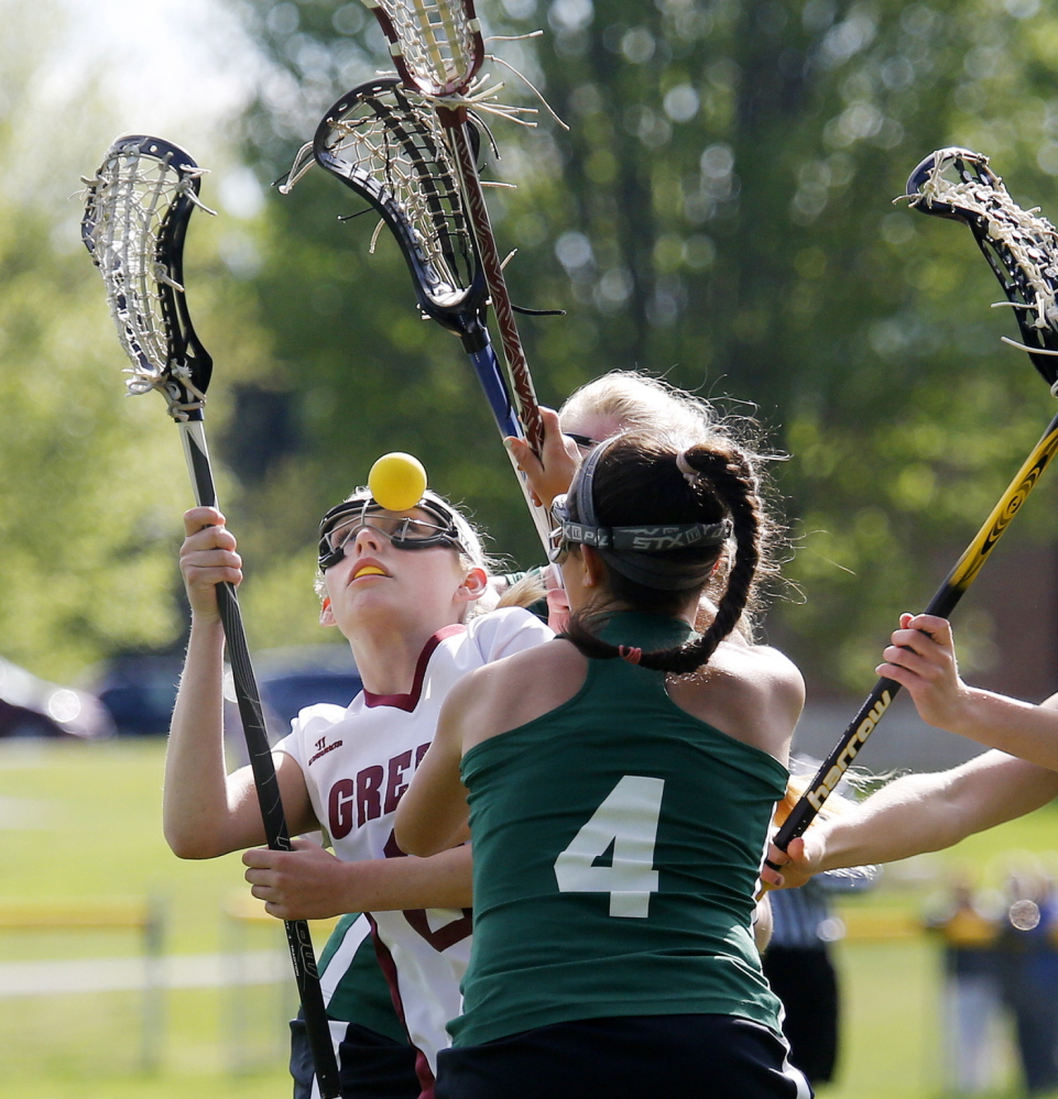 Cameron Keefe of Greely gets a close look – a darn close look – at the lacrosse ball Wednesday while attempting to find a way through Waynflete’s defense, including Sofia Canning, foreground. Greely had opportunities but ended up falling 11-8 to a team that’s won six straight Western Maine championships.