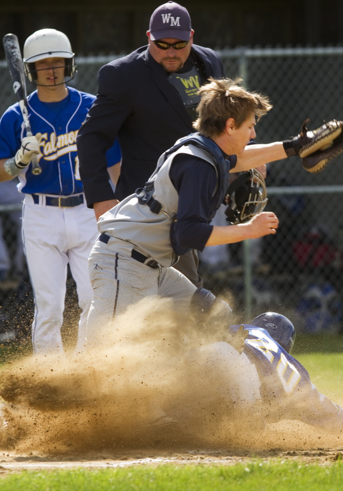 Connor Aube of Falmouth slides safely into the plate as Yarmouth catcher Ryan Nason collects a late throw during the first inning of their game at Falmouth.